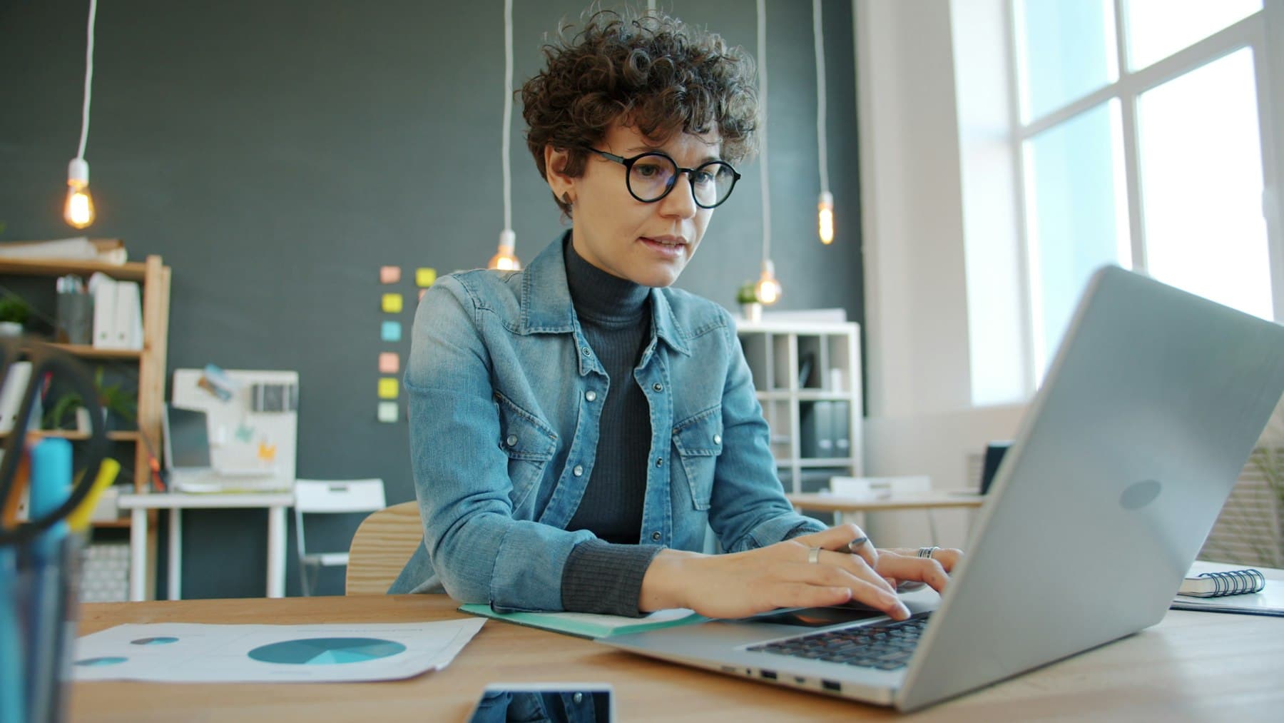 A professional working on a laptop in a modern office